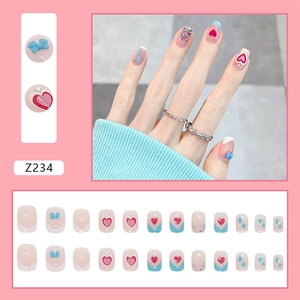 Detail of pink press-on nails featuring 3D blue bows and red heart patterns in set Z234