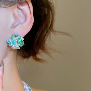 Detailed close-up of 18k gold butterfly crystal floral stud earrings worn on a model