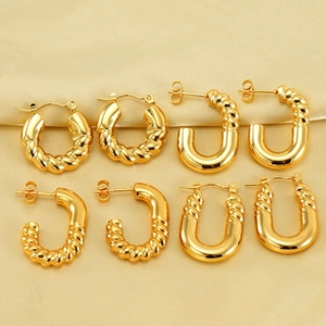 Vue détaillée du lot de boucles d'oreilles créoles torsadées dorées sur satin