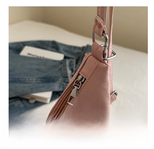 Close-up of pink leather underarm bag with silver zipper and bunny logo detail