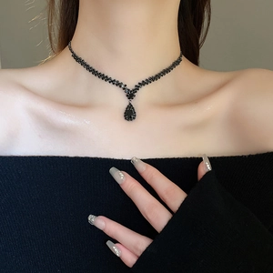 Macro shot of elegant black crystal water drop pendant necklace and woven beaded chain