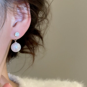 Close-up of vintage zircon and pearl drop earring worn on a model with elegant style