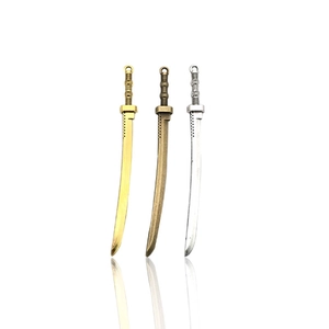 Tre ciondoli a forma di spada vintage in lega, finiture oro, bronzo e argento con riflesso