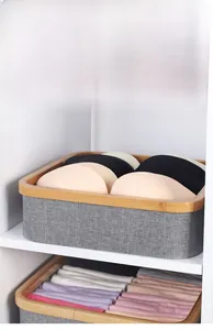 Grey fabric storage basket with bamboo frame used for organizing clothes in closet