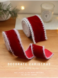 Close-up of red velvet Christmas ribbon with white faux fur edges on wooden background