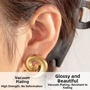 Close-up of gold spiral starfish earrings featuring vacuum plating on model ear