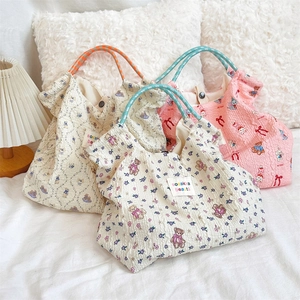 Detail view of cartoon puppy canvas handbags in beige and pink on a cozy soft background