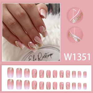 Short pink gradient press-on nails with gold glitter, white curves and heart patterns