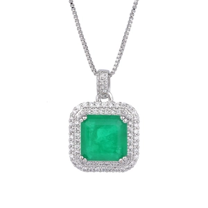 Gros plan du collier pendentif émeraude carrée avec double halo de cristaux