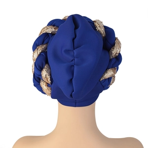 Detail of navy blue turban featuring a braided gold sequin trim and textured fabric
