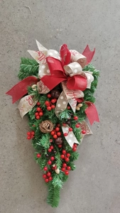 Detail of Christmas teardrop swag with red berries, pine needles, bells and Joy ribbon