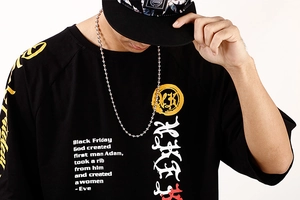 Detail of black cotton T-shirt featuring a vintage Adam and Eve graphic and bold typography