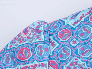 Macro shot of quilted cotton fabric with colorful geometric floral prints and stitching