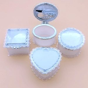Detalle de cajas de corazón en colores pastel con encaje plateado y espejo integrado