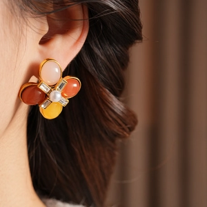 Gros plan de boucles d'oreilles fleurs vintage avec pétales colorés et perles blanches