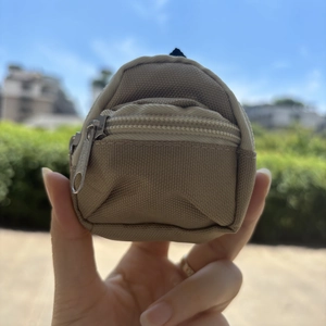 Close-up of a khaki mini canvas backpack coin purse with dual zipper compartments