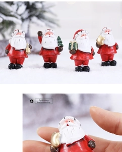 Set of four resin Santa Claus figurines with bell, tree, gift box, and golden star