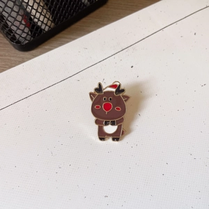 Close-up of cute cartoon reindeer brooch with brown enamel finish and golden metal edges