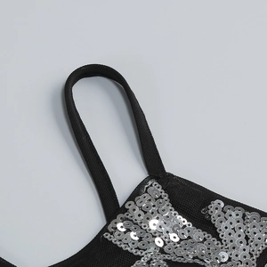 Détail de maille noire avec paillettes argentées denses et fine bandoulière