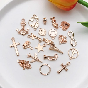 Collection of rose gold alloy charms including anchors, stars, and Eiffel Tower on a white plate