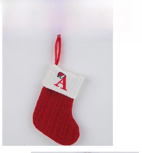 Detail of red knit Christmas stocking with white cuff and embroidered letter A