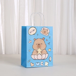 Close-up of a blue Capybara gift bag with It's OK print and rope handles on white background