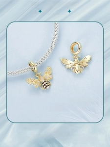 Macro detail of S925 sterling silver gold-plated bee charms with sparkling zircon pavé
