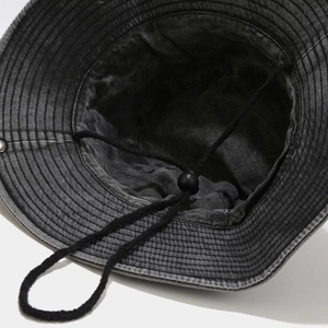 Close-up of the washed cotton fabric texture and adjustable windproof chin strap buckle