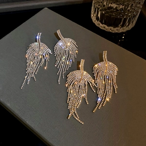 Detailed close-up of silver leaf tassel earrings featuring sparkling rhinestones and crystal fire