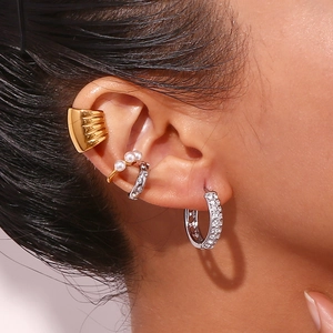 Close-up of stacked gold and silver hoop earrings with pearls and crystal pavé on ear