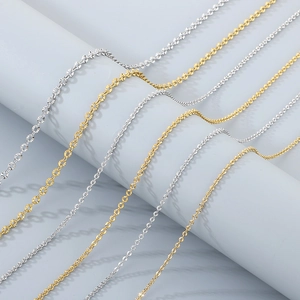 Detailed view of polished gold and silver stainless steel flat chains on a display