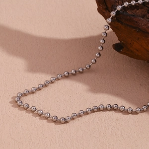 Macro view of polished 4mm silver metal bead chain necklace with reflective finish