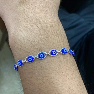 Classic silver evil eye bracelet with blue and white charms on a female wrist