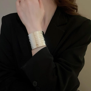 Detailed macro view of irregular crumpled texture on metallic open cuff bracelet