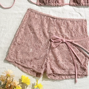 Detail view of pink floral lace shorts with side-tie ribbons and delicate texture