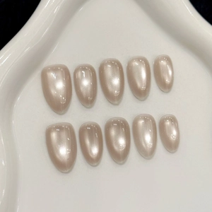 Sparkling champagne cat-eye almond press-on nails set on white ceramic tray