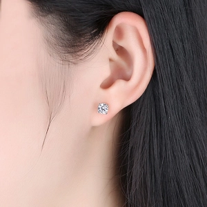 Classic silver four-prong round zircon stud earrings set worn by a fashion model