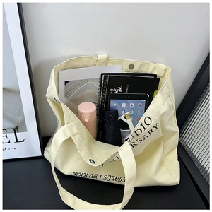 Spacious beige canvas tote bag with letter print showing large storage capacity