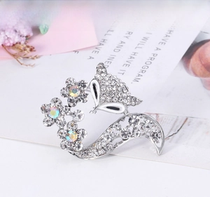 Détail de la broche renard argentée ornée de strass brillants et de petites fleurs colorées