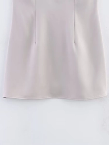 Detail shot of the hemline stitching and structural seams on a rhinestone tube mini dress
