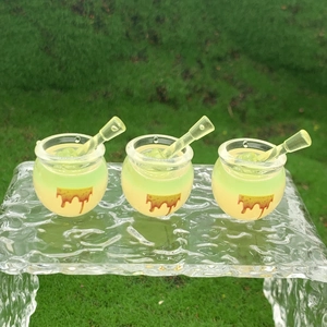 Macro shot of miniature honey jars with stirrers on crystal blocks in nature