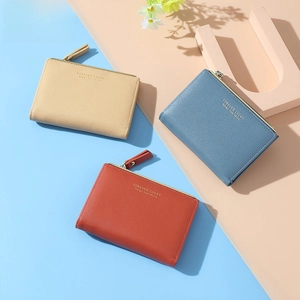 Three compact faux leather wallets in tan, blue, and red with gold lettering detail