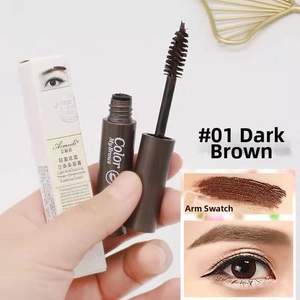 Macro shot of waterproof eyebrow cream in deep brown with spiral applicator brush