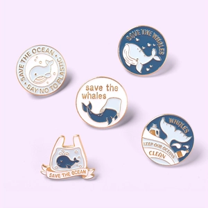 Set of 5 enamel whale pins with Save the Ocean slogans on a lavender background