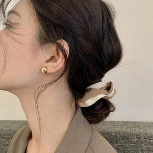 French style gold bean earrings and minimalist brown scrunchie shown on model