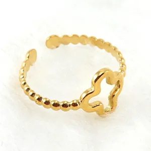Detailed macro view of gold-plated clover ring featuring beaded open band design