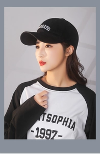 Detail of black cotton baseball cap with white Colorado embroidery on a female model