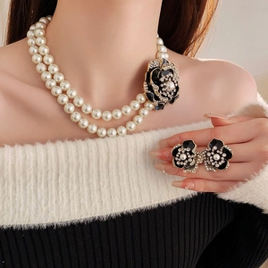 Detail of vintage French flower jewelry set with double-row pearls and black floral earrings