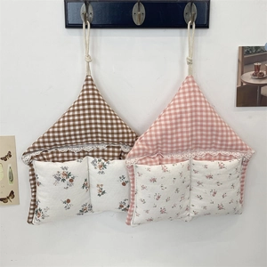 Detail of hanging macaron plaid storage bags with floral pockets and lace trim accents