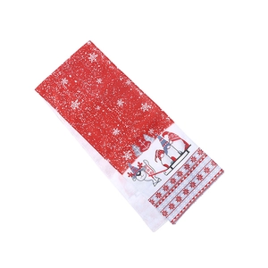 Christmas table runner with festive gnomes and reindeer patterns on red cotton fabric